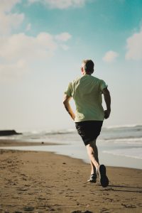Keeping healthy in the workplace: Man running on the beach