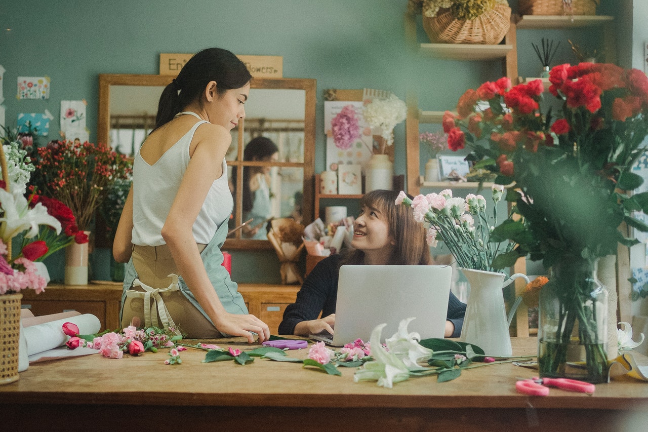 A flower shop owner completes payroll for her employee